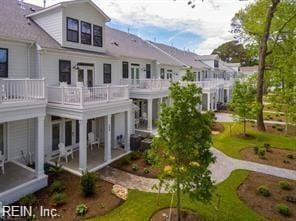 rear view of property with a lawn and a balcony