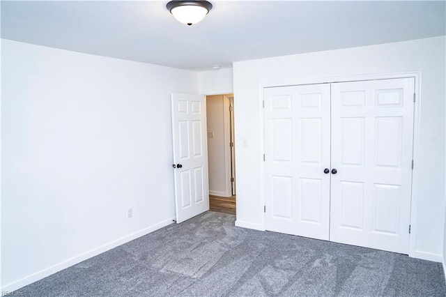 unfurnished bedroom featuring dark carpet and a closet