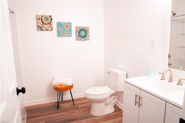 bathroom with wood-type flooring, vanity, and toilet