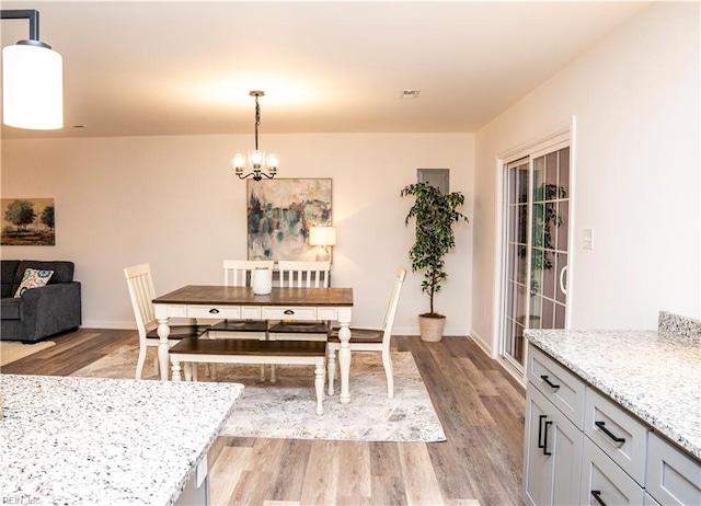 dining area featuring an inviting chandelier and light hardwood / wood-style flooring