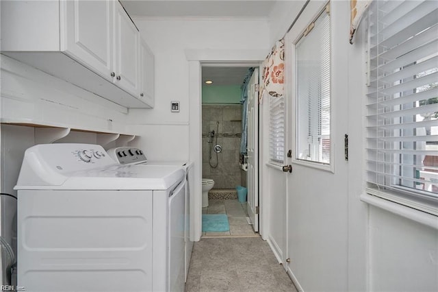 laundry room with crown molding, cabinets, washer and clothes dryer, and a healthy amount of sunlight