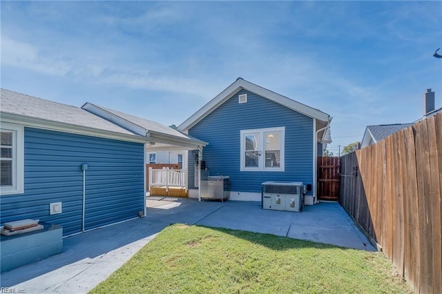 rear view of property with a patio area and a lawn