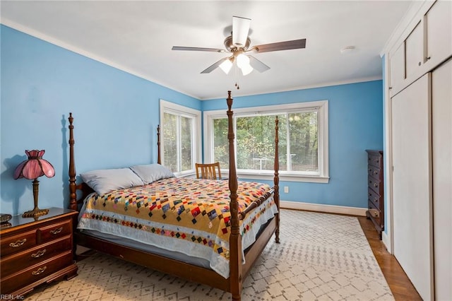 bedroom with hardwood / wood-style flooring, ceiling fan, and crown molding