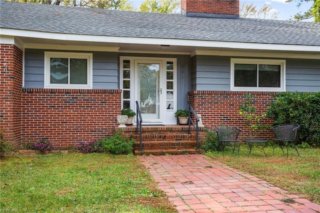 view of exterior entry featuring a lawn