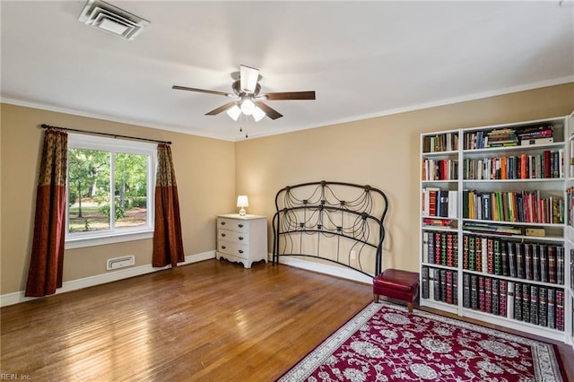 bedroom with hardwood / wood-style flooring, ceiling fan, and ornamental molding