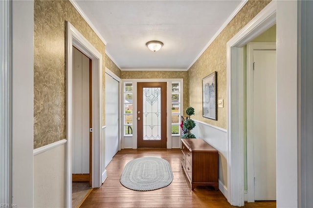 doorway to outside featuring light hardwood / wood-style floors and ornamental molding