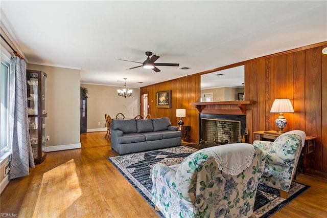 living room with light hardwood / wood-style floors, ornamental molding, and wooden walls