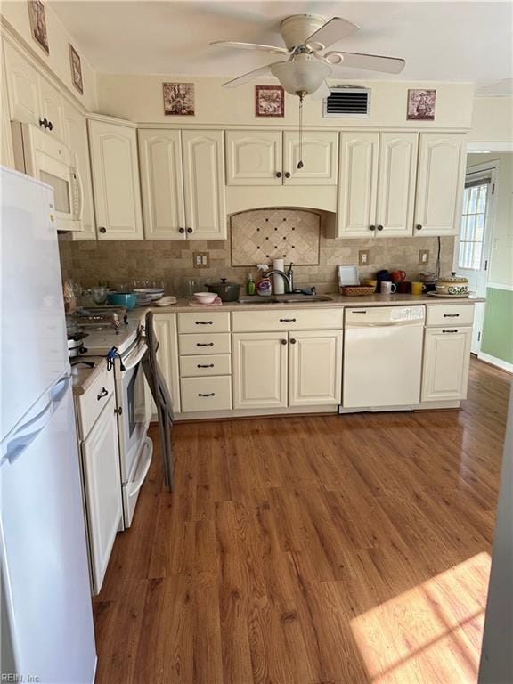 kitchen featuring ceiling fan, sink, dark hardwood / wood-style floors, backsplash, and white appliances