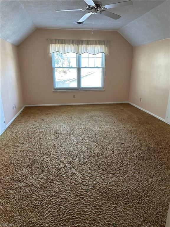 additional living space with ceiling fan, carpet floors, a textured ceiling, and vaulted ceiling