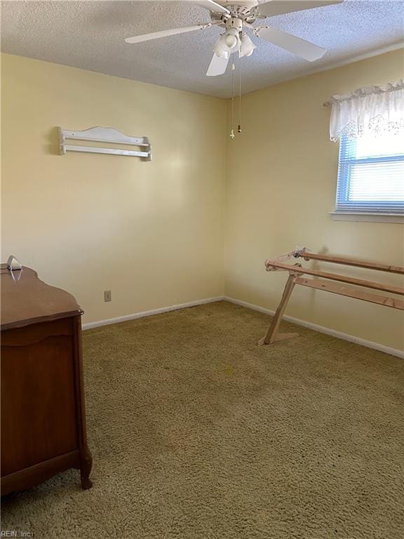 empty room featuring ceiling fan, carpet floors, and a textured ceiling