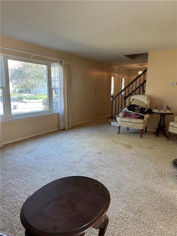 carpeted living room featuring a textured ceiling