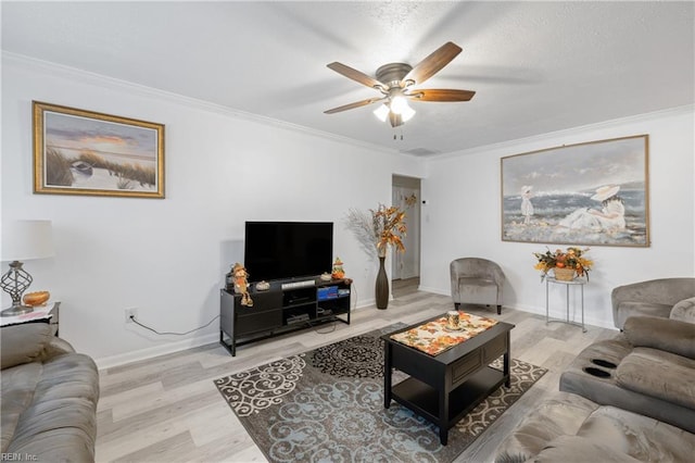 living room with light hardwood / wood-style floors, ceiling fan, and ornamental molding