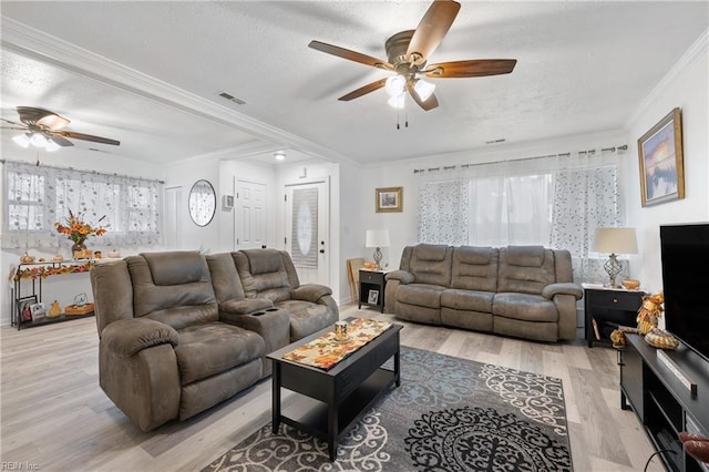 living room with ceiling fan, ornamental molding, and light wood-type flooring