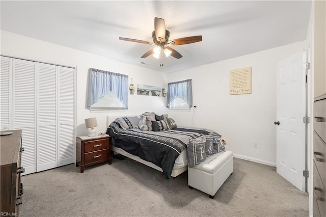 bedroom featuring ceiling fan, a closet, and light colored carpet