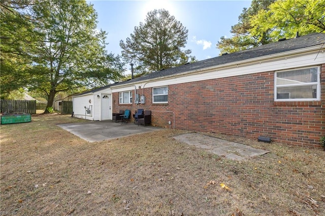 back of property with a yard and a patio