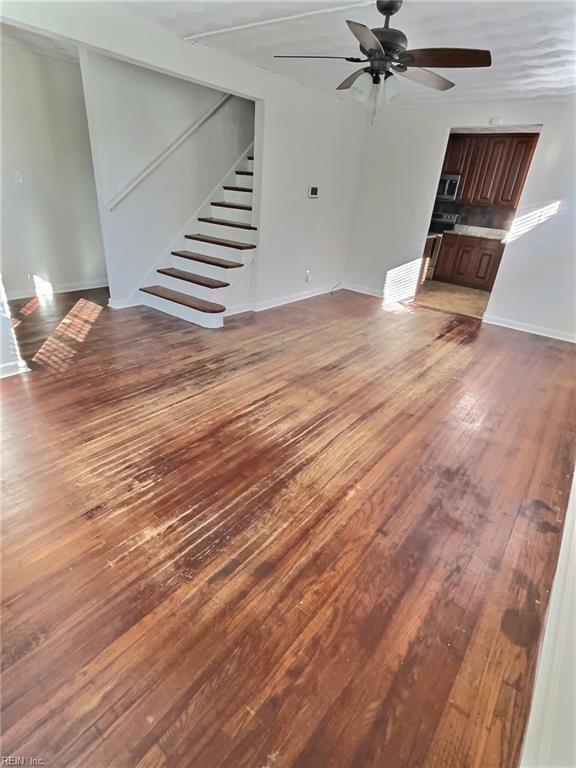 unfurnished living room with hardwood / wood-style floors and ceiling fan