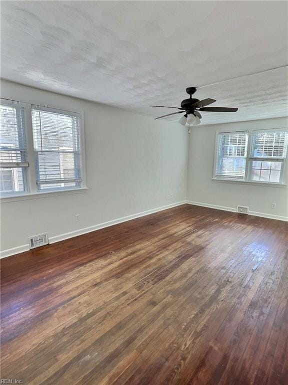 empty room featuring ceiling fan, dark hardwood / wood-style flooring, and a textured ceiling