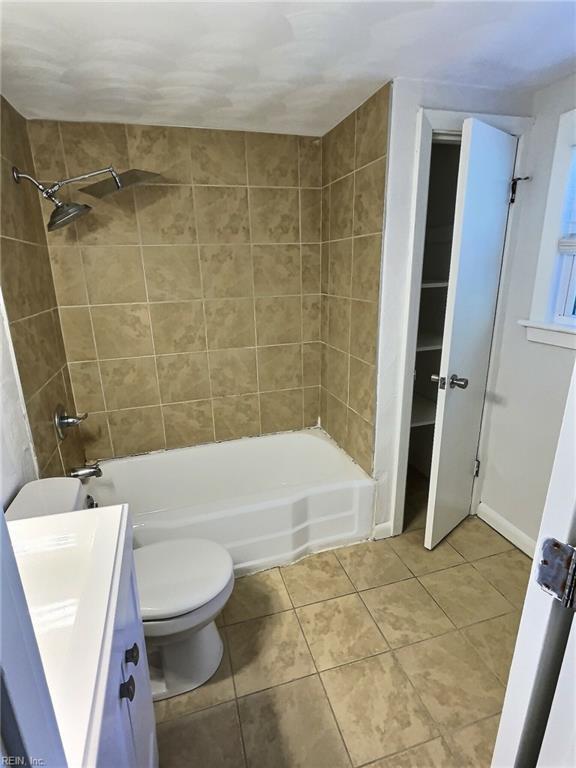 full bathroom with tile patterned flooring, vanity, toilet, and tiled shower / bath