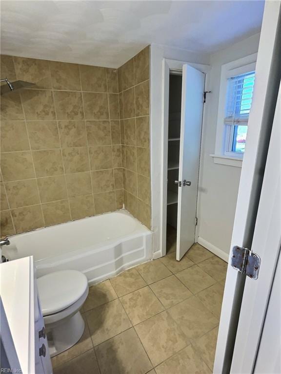 full bathroom with tile patterned flooring, tiled shower / bath combo, toilet, and vanity