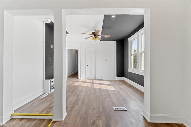 unfurnished living room featuring ceiling fan and hardwood / wood-style flooring