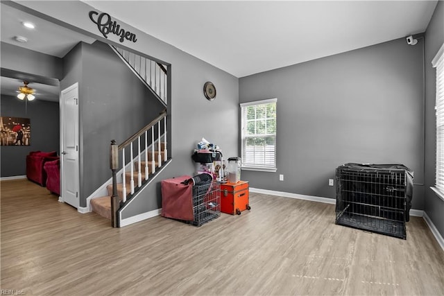 staircase with ceiling fan and wood-type flooring