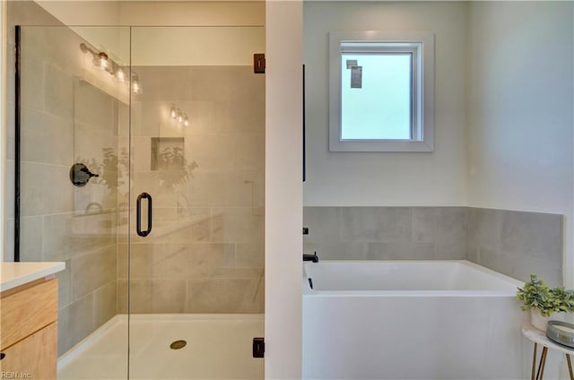 bathroom with shower with separate bathtub and vanity