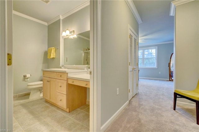 bathroom with tile patterned floors, vanity, toilet, and ornamental molding