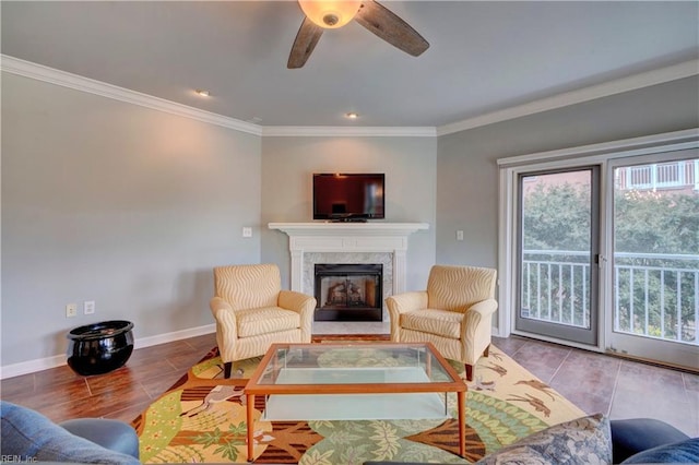 living room featuring ceiling fan, crown molding, and a fireplace