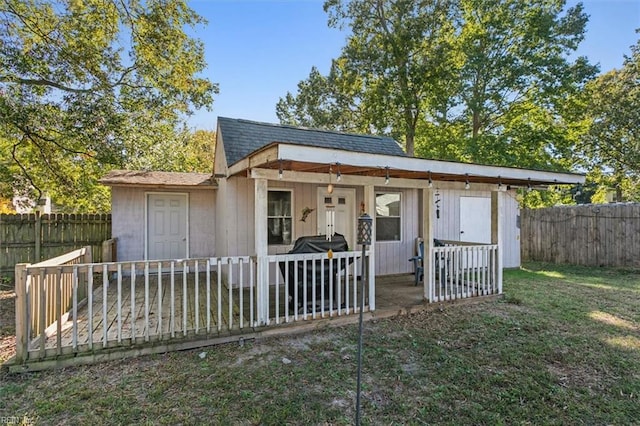 bungalow featuring an outbuilding and a front lawn