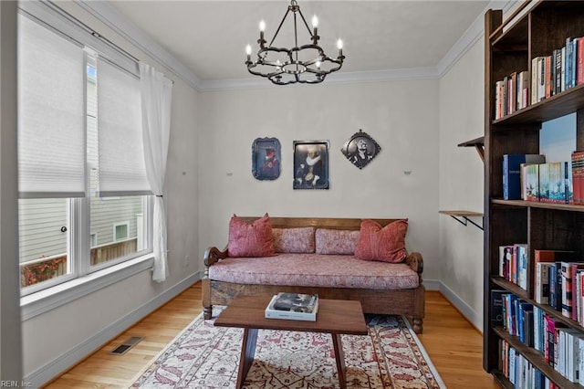 sitting room featuring light hardwood / wood-style flooring, a chandelier, and ornamental molding