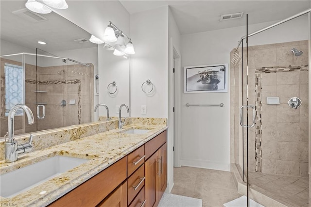 bathroom with tile patterned flooring, vanity, and a shower with door