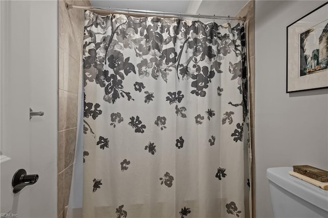 bathroom with toilet and curtained shower