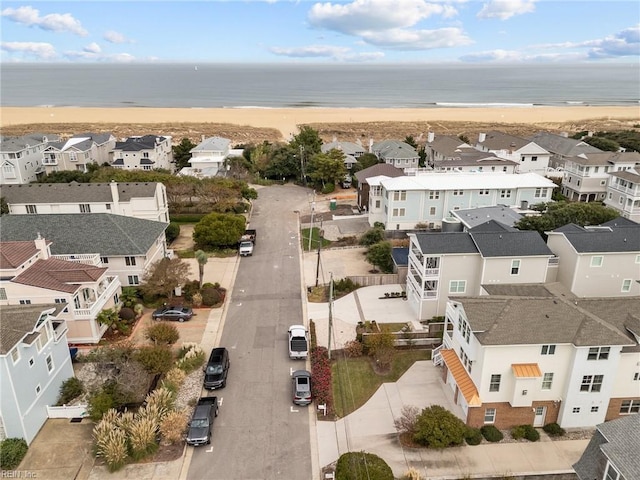 birds eye view of property with a water view and a beach view