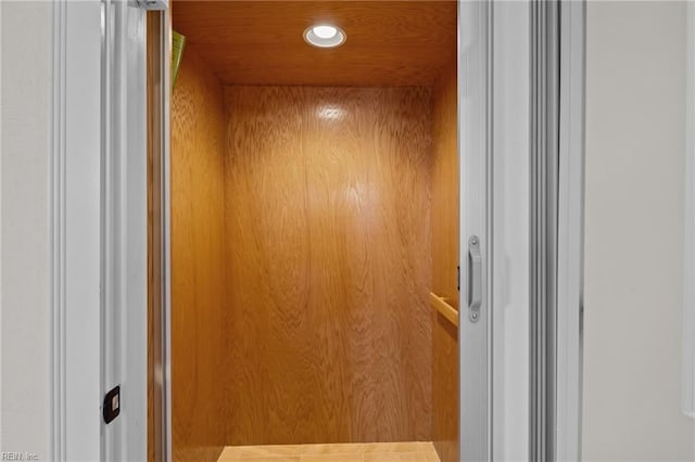 room details with elevator, wood walls, and wooden ceiling