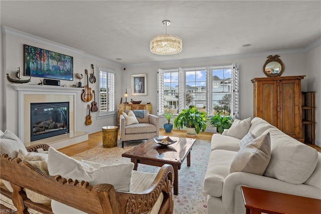 living room with an inviting chandelier, light hardwood / wood-style flooring, and crown molding