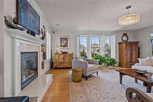 living room featuring light hardwood / wood-style floors, an inviting chandelier, and crown molding