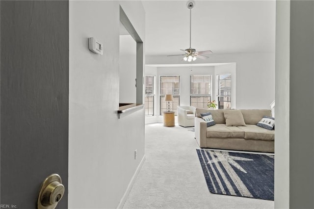 carpeted living room with ceiling fan