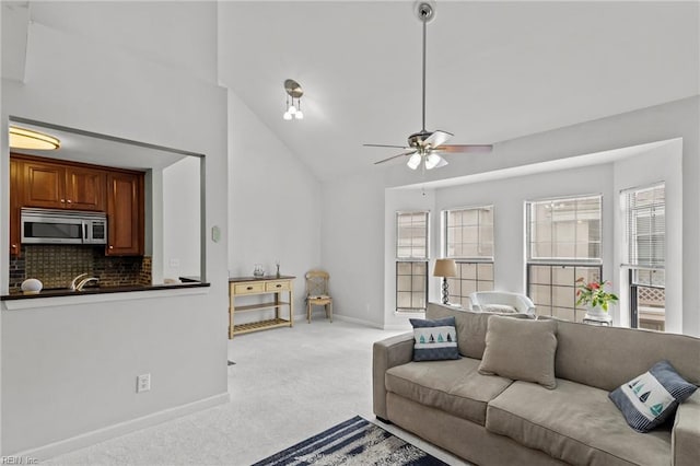 living room featuring light carpet, high vaulted ceiling, and ceiling fan