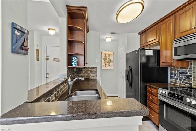 kitchen with tasteful backsplash, kitchen peninsula, sink, and appliances with stainless steel finishes