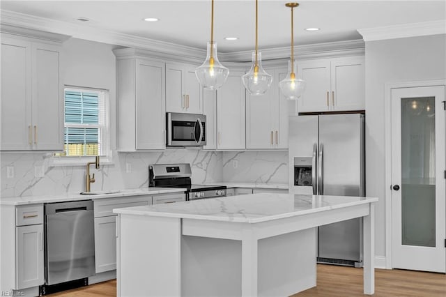 kitchen with appliances with stainless steel finishes, a center island, decorative light fixtures, light stone countertops, and sink