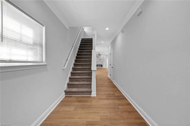 staircase featuring crown molding and hardwood / wood-style flooring