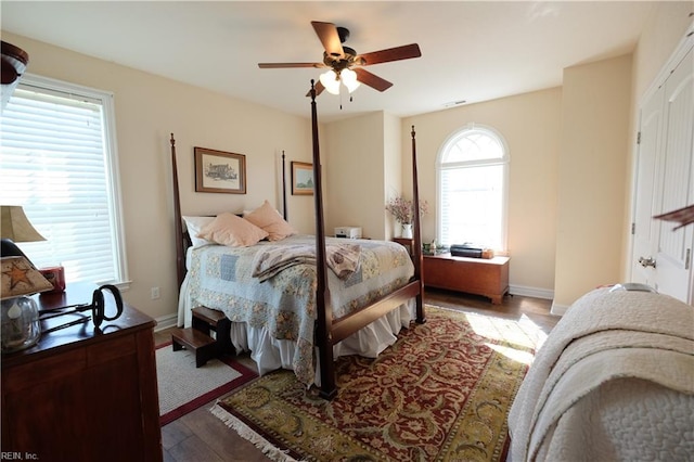 bedroom featuring hardwood / wood-style floors, ceiling fan, and multiple windows