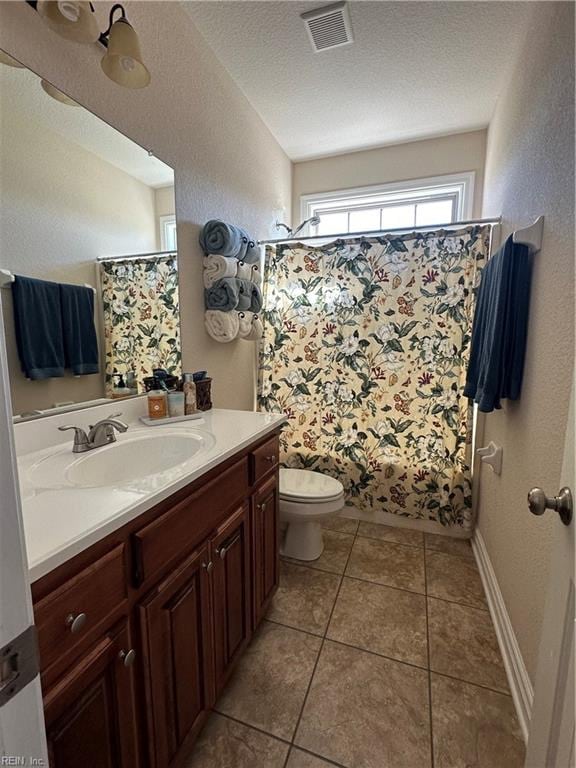 full bathroom with shower / bathtub combination with curtain, tile patterned floors, a textured ceiling, toilet, and vanity