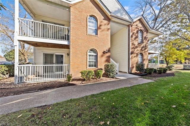 view of front of home featuring a front yard and a balcony