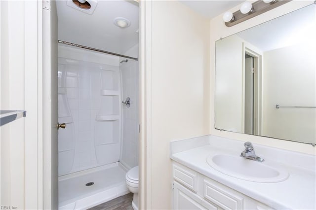 bathroom featuring hardwood / wood-style floors, vanity, toilet, and walk in shower