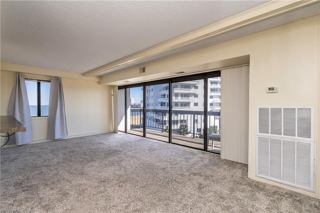 carpeted empty room featuring a textured ceiling