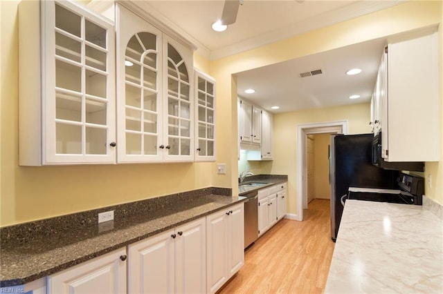 kitchen featuring white cabinetry, stainless steel dishwasher, black / electric stove, dark stone counters, and light wood-type flooring