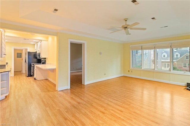 unfurnished living room with ceiling fan, ornamental molding, and light wood-type flooring