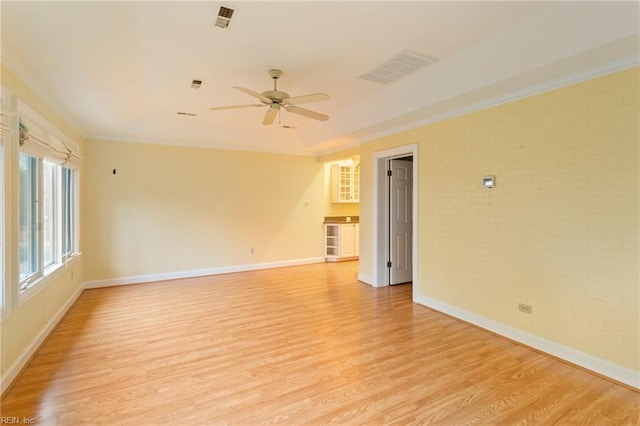 empty room featuring ceiling fan, light hardwood / wood-style floors, and ornamental molding