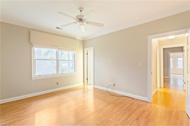 empty room featuring ceiling fan, ornamental molding, and light hardwood / wood-style flooring